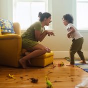 Mother and son imitating a dinosaur in their play area. Happy mother and son having fun together during playtime. Loving single mother spending some quality time with her son at home.